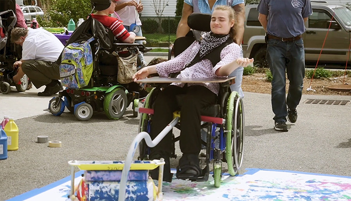 Woman painting with her wheelchair wheels