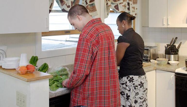 Assistance with daily tasks, two people standing at a sink, preparing dinner